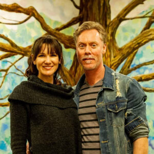 Leigh MacLeod and Geoff Farnsworth in front of the Community Tree mural at the Canadian Mental Health Association (CMHA) of Niagara waiting room, 2019